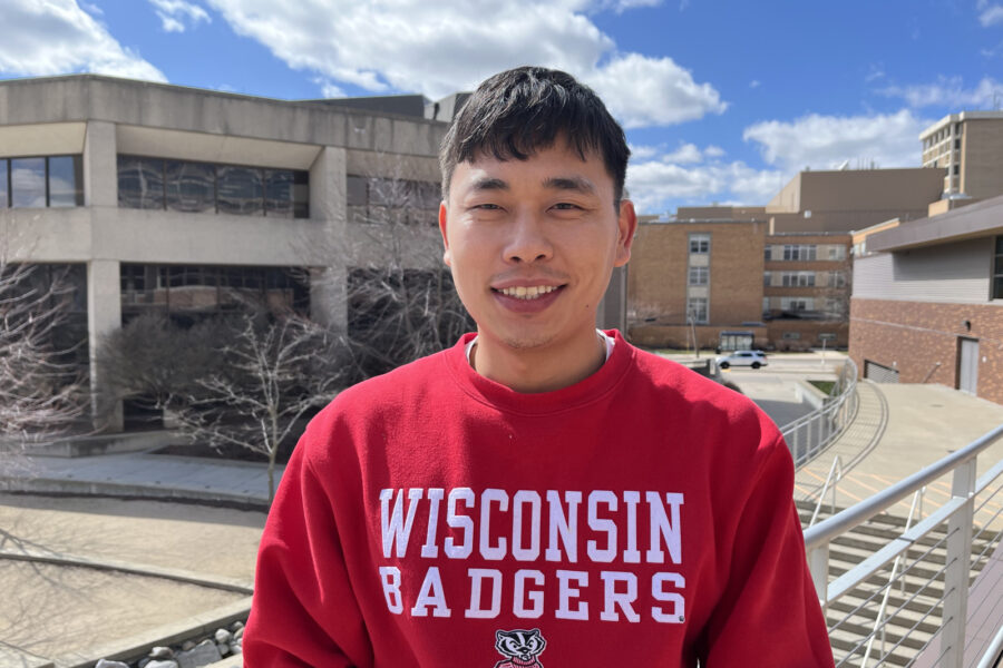 Photo of Tenzin Phuntsok wearing a red Wisconsin Badger sweatshirt and smiling